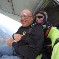 man smiles nervously before exiting the skydiving plane at Eugene Skydivers