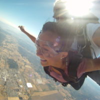 young woman smiles as she freefalls over the Willamette Valley in Oregon