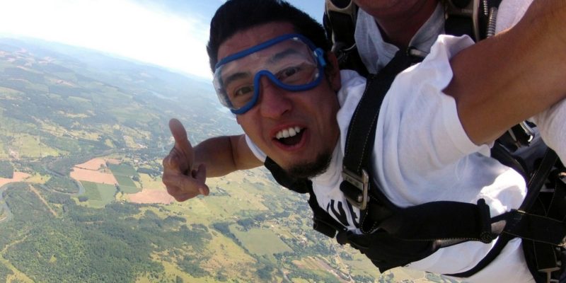 young man smiles during skydiving freefall at Eugene Skydivers